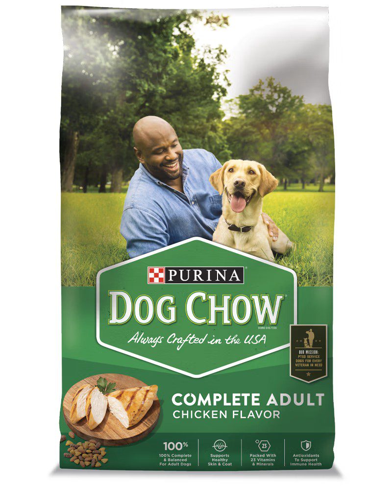 Purina Dog Chow Complete Adult Chicken Flavor green bag with happy man and golden retriever in park background
