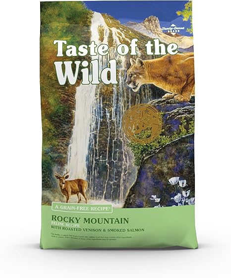 Taste of the Wild Rocky Mountain cat food bag featuring a scenic mountain landscape with waterfall, deer, and cougar in a natural wilderness setting, highlighting grain-free formula with roasted venison and smoked salmon.
